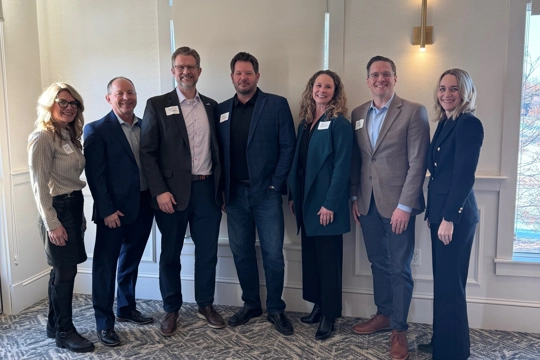 group of people wearing professional attire standing in a line posing for the picture